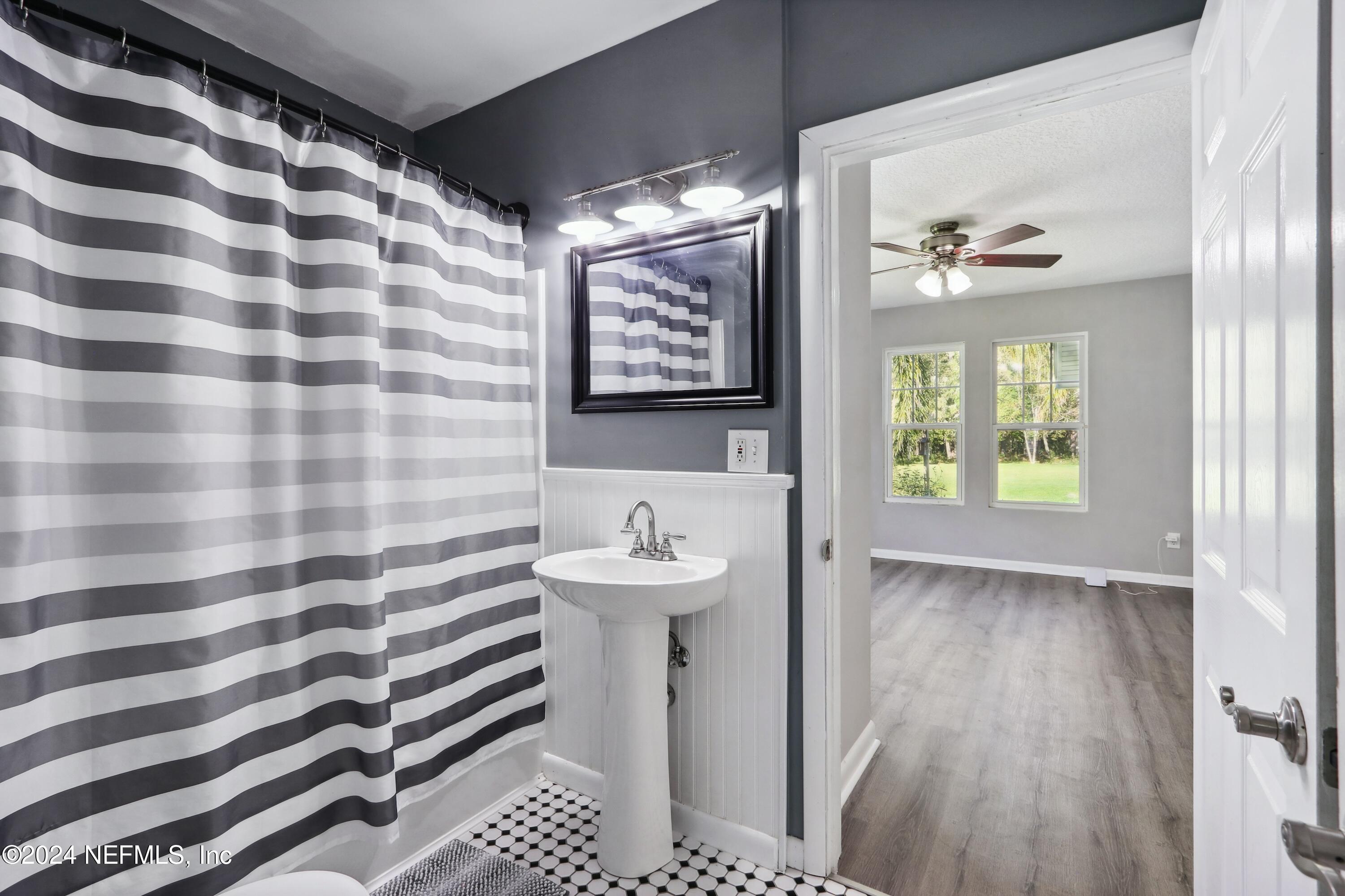 3629 Capper Road Jacksonville, FL 32218 - Photo 9 of 26 a bathroom with a sink a mirror and a window