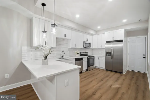 a kitchen with kitchen island a sink stainless steel appliances and cabinets