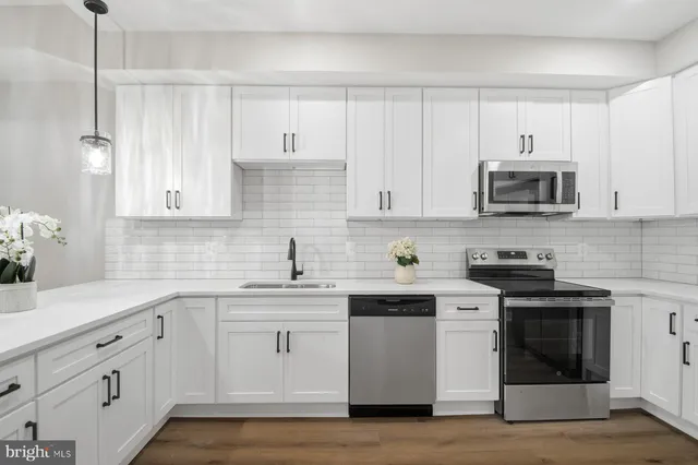 a kitchen with cabinets stainless steel appliances and a sink