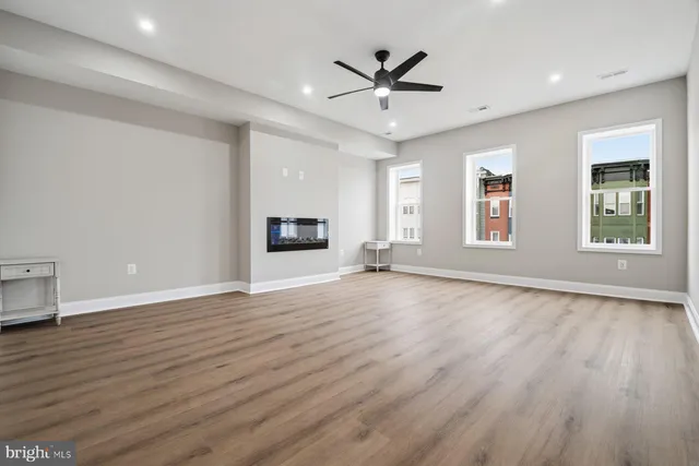 a view of empty room with wooden floor and window