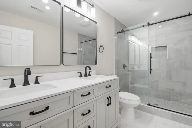 a bathroom with a sink a toilet and shower