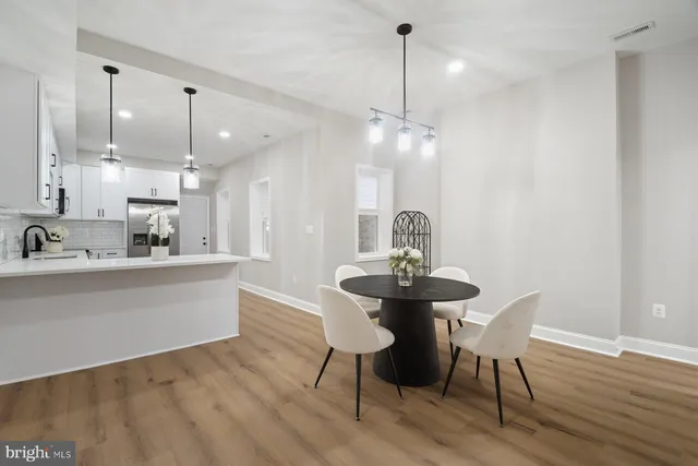 a view of a dining room and livingroom with furniture wooden floor a chandelier