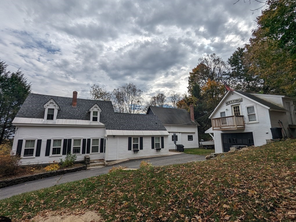 622 Turnpike Road New Ipswich, NH 03071 - Photo 5 of 30 a front view of a house with a garden and trees