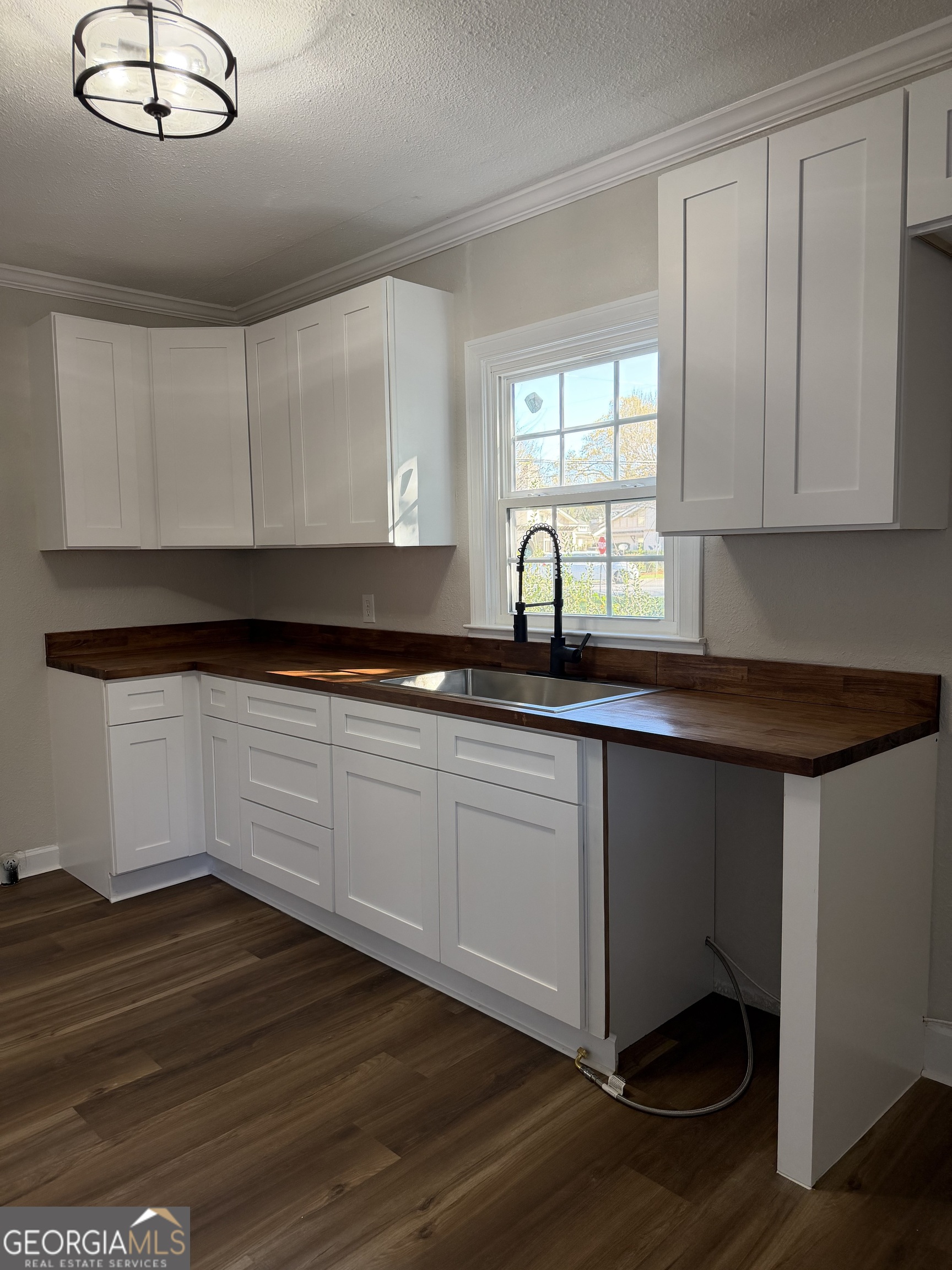 1502 Stonewall Street Dublin, GA 31021 - Photo 13 of 24 a kitchen with granite countertop a stove a sink and white cabinets