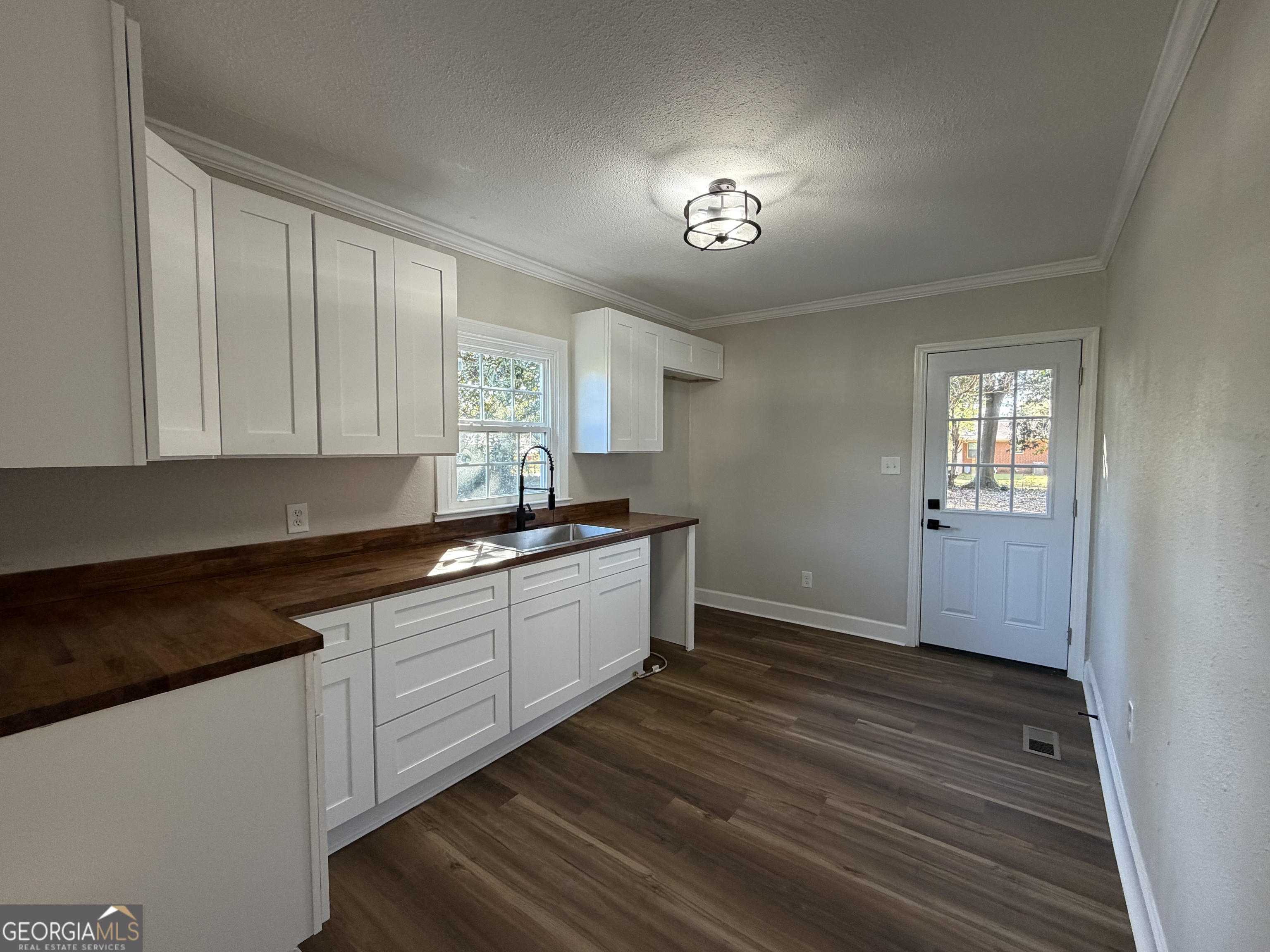 1502 Stonewall Street Dublin, GA 31021 - Photo 14 of 24 a kitchen with granite countertop white cabinets and white appliances
