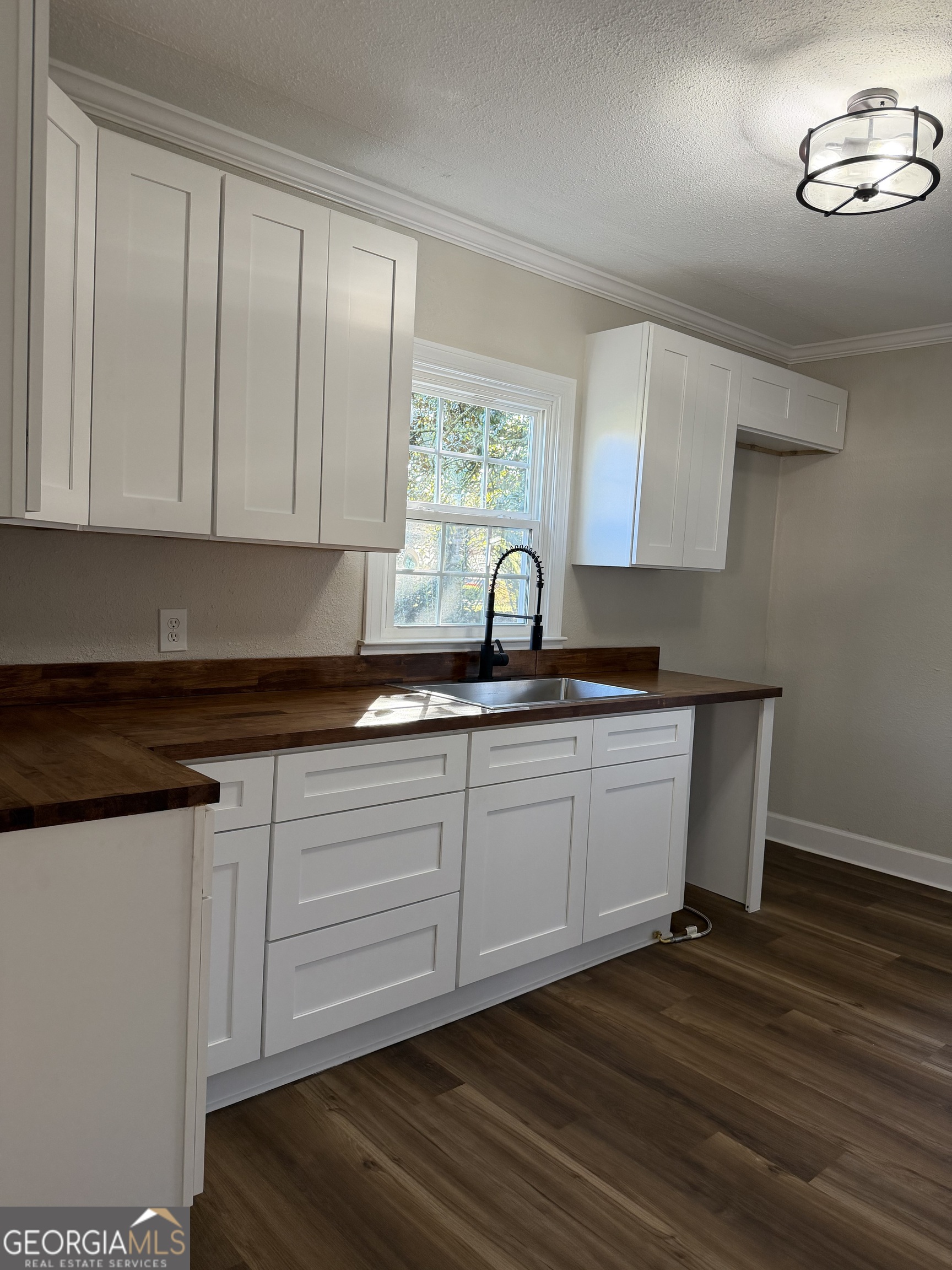 1502 Stonewall Street Dublin, GA 31021 - Photo 9 of 24 a kitchen with wooden cabinets a sink and dishwasher