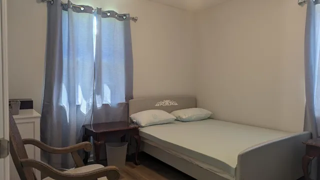 a bedroom with a bed a table and a chair