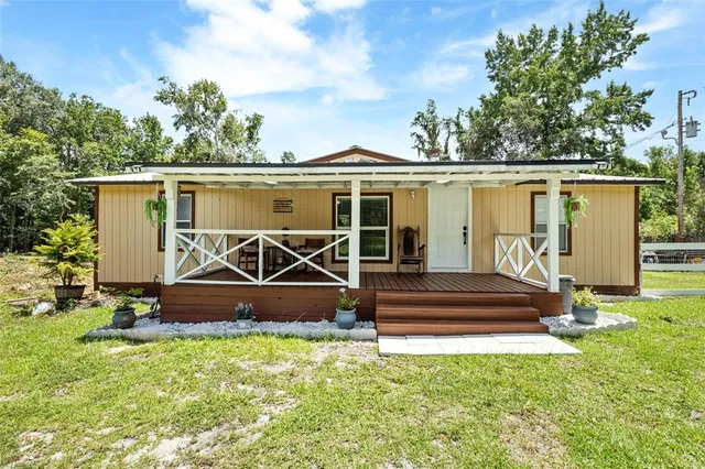 a view of a house with backyard and a tree