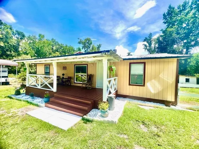 a view of a house with backyard porch and sitting area