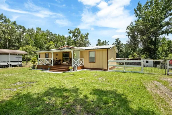 a view of a house with backyard and porch