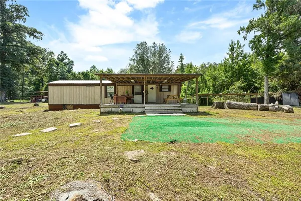 a view of backyard with swimming pool and trees