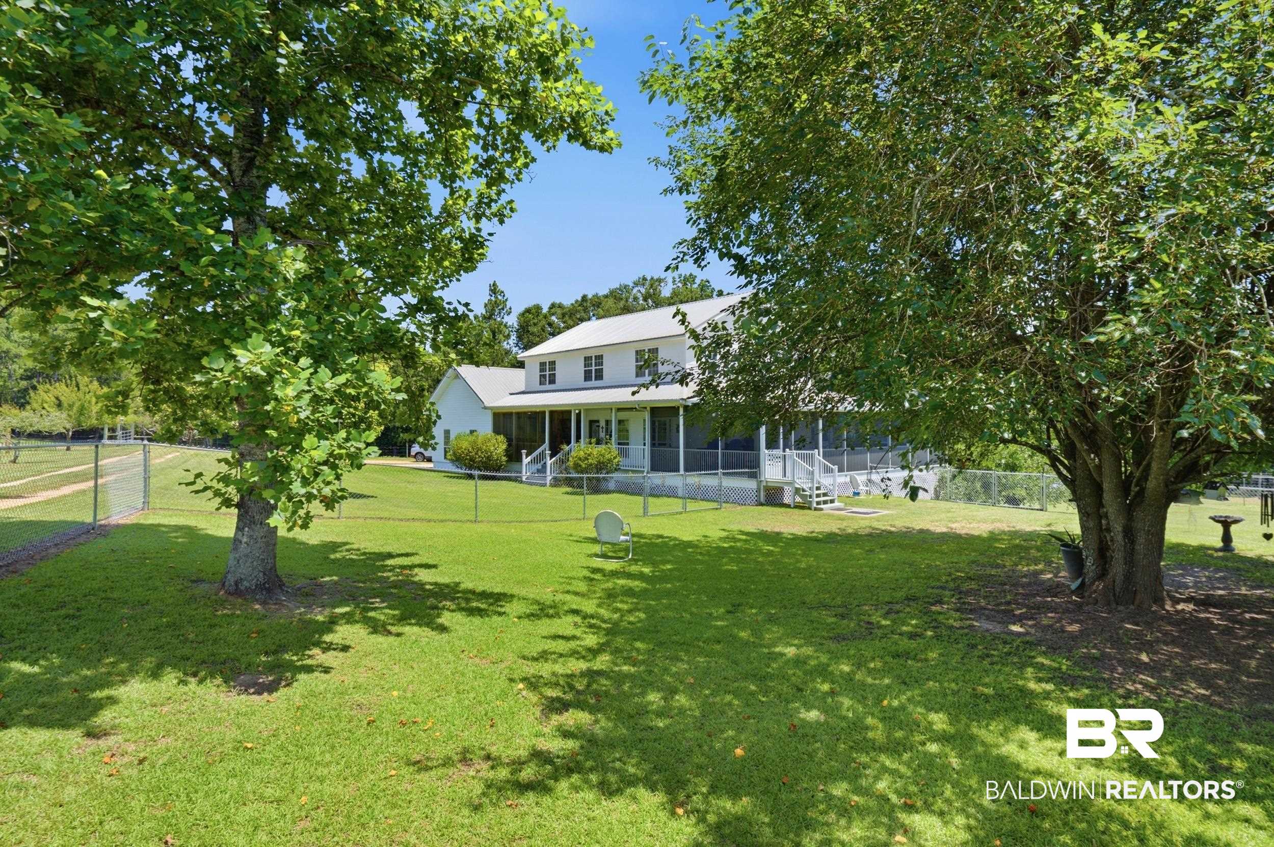 15855 Calvin Richerson Road Bay Minette, AL 36507 - Photo 4 of 83 Expansive green lawn with mature shade trees and a chain-link fence enclosing the property
