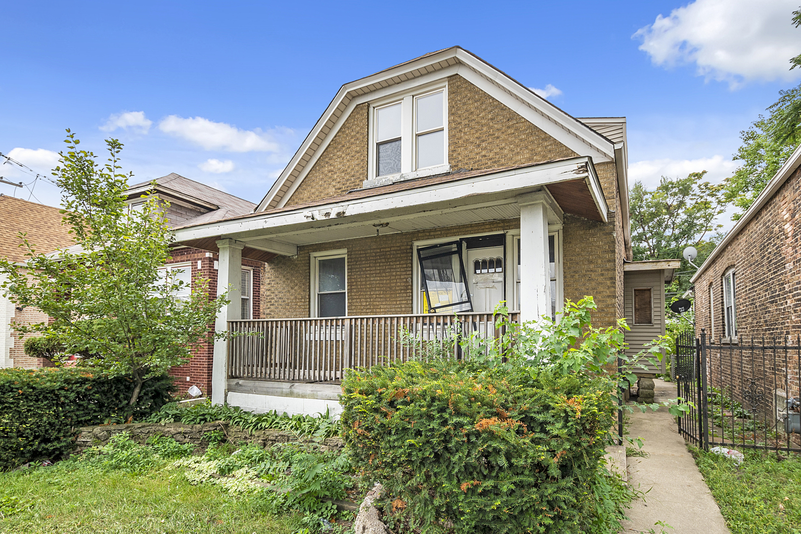 a view of a house with potted plants and a large tree