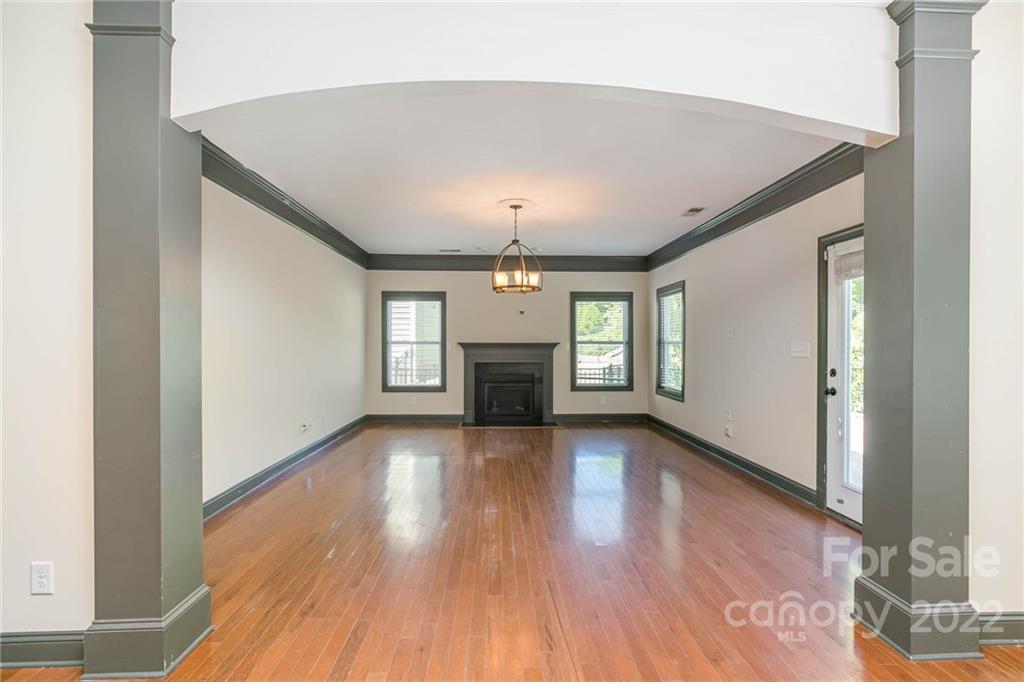 1000 Ridgehaven Road Waxhaw, NC 28173 - Photo 5 of 22 an empty room with wooden floor fireplace and windows
