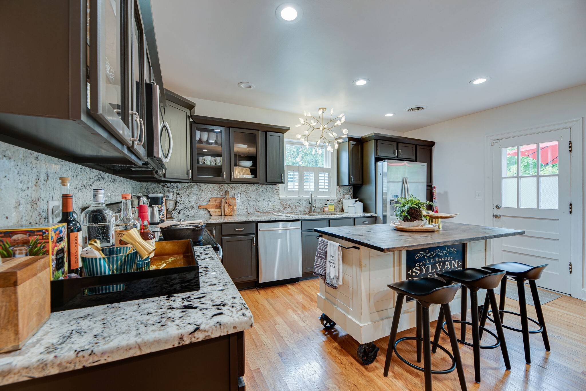 1715 Holly Street Nashville, TN 37206 - Photo 15 of 54 a kitchen with stainless steel appliances kitchen island granite countertop a table chairs in it and wooden floors