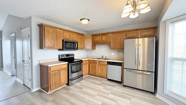 a kitchen with a refrigerator sink and wooden cabinets