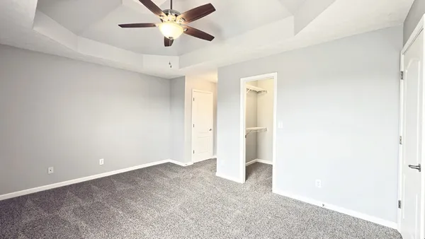 an empty room with a ceiling fan and a window