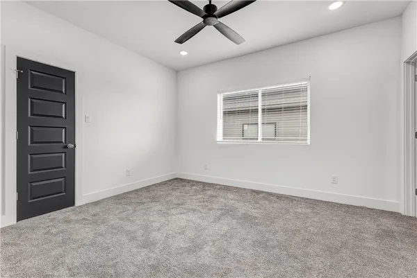 a view of a livingroom with a ceiling fan & windows
