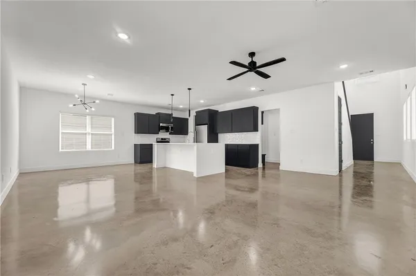 a view of a electric appliances in kitchen and empty room with windows