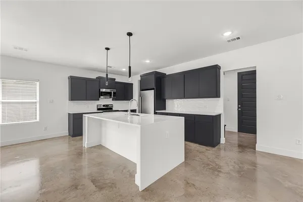 a large kitchen with kitchen island a sink a center island and stainless steel appliances