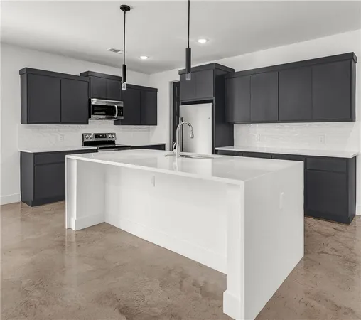 a kitchen with stainless steel appliances a microwave a sink and refrigerator