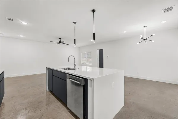 a kitchen with a sink a stove and chairs
