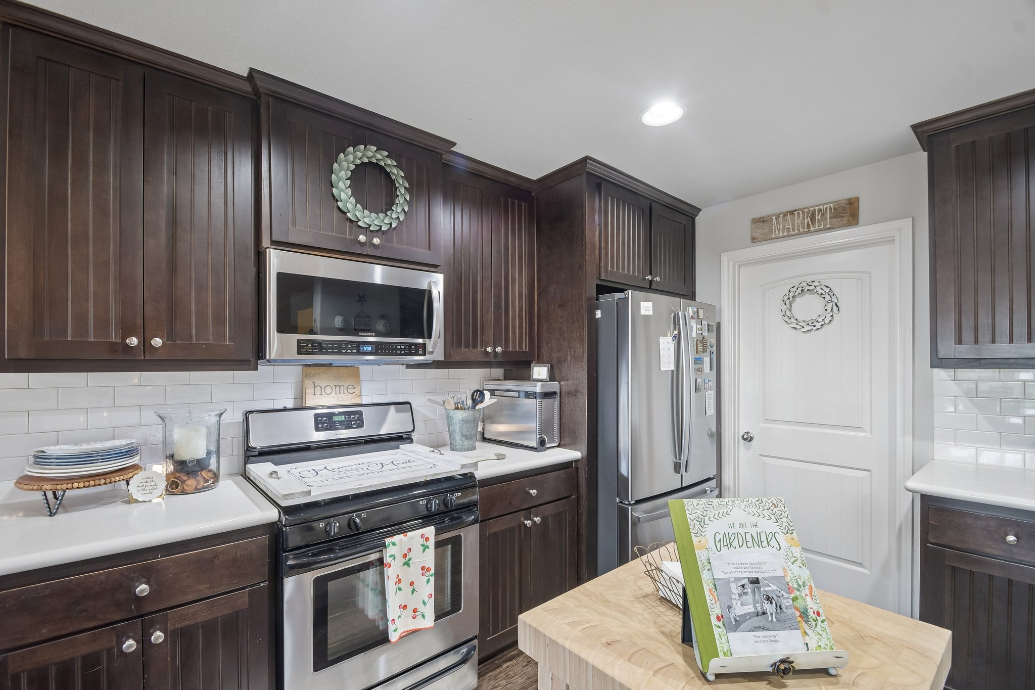596 Pleasant Grove Loop Elgin, TX 78621 - Photo 12 of 37 Rich dark wood cabinets contrast beautifully with classic white subway tile in this updated kitchen.
