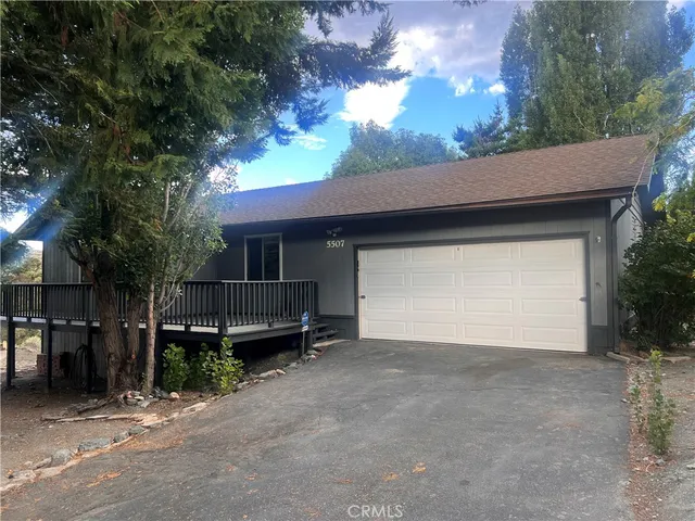 a view of a house with a backyard and garage