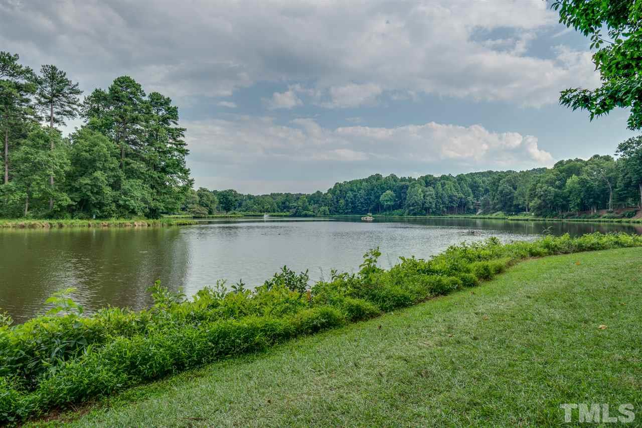 7604 Kelmscot Way Raleigh, NC 27615 - Photo 2 of 30 a view of a lake with a big yard and large trees