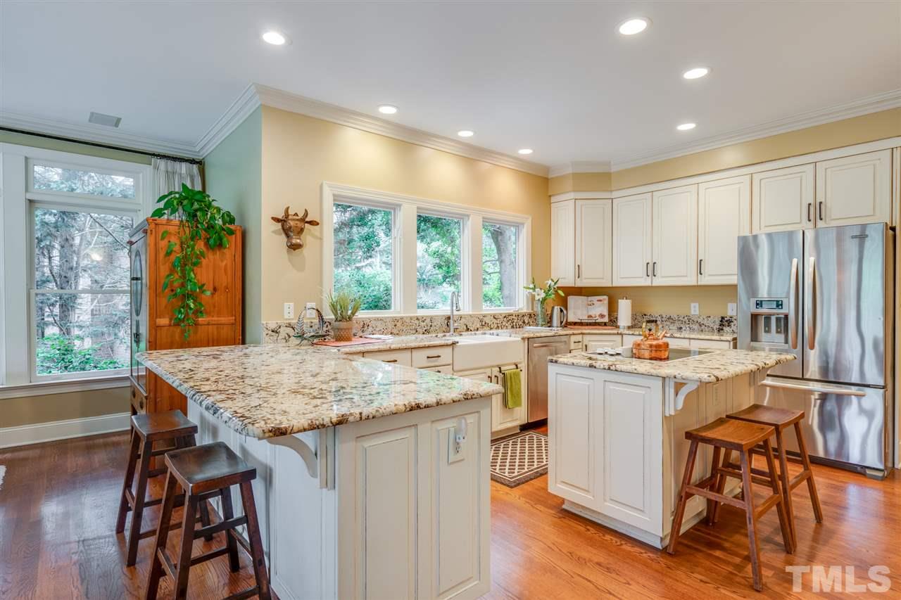 7604 Kelmscot Way Raleigh, NC 27615 - Photo 12 of 30 a kitchen with a table chairs refrigerator and cabinets