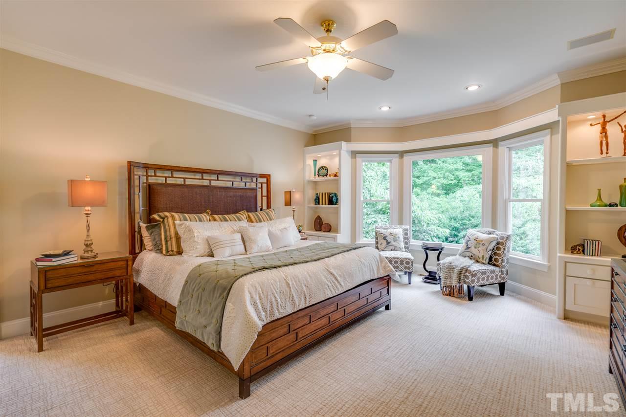 7604 Kelmscot Way Raleigh, NC 27615 - Photo 17 of 30 a spacious bedroom with a bed and a chandelier