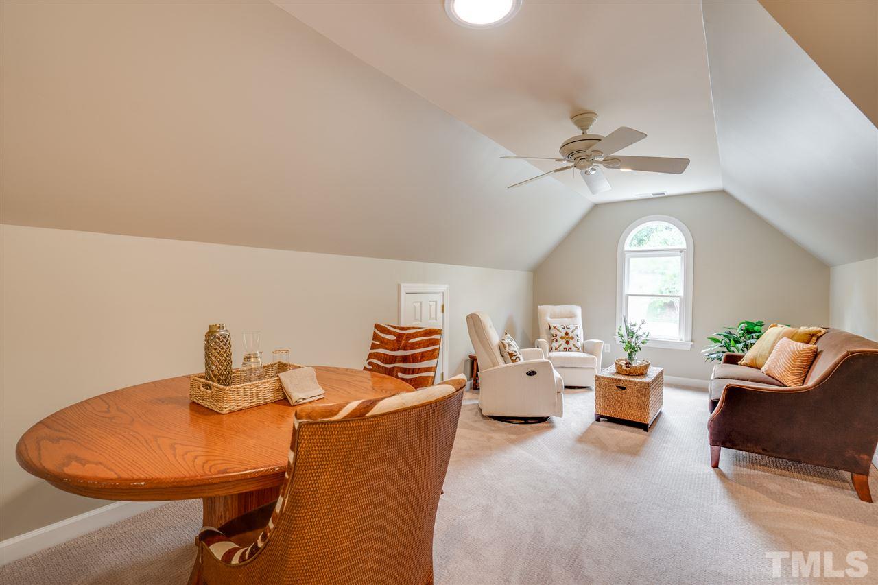 7604 Kelmscot Way Raleigh, NC 27615 - Photo 22 of 30 a living room with couches a fireplace and a chandelier