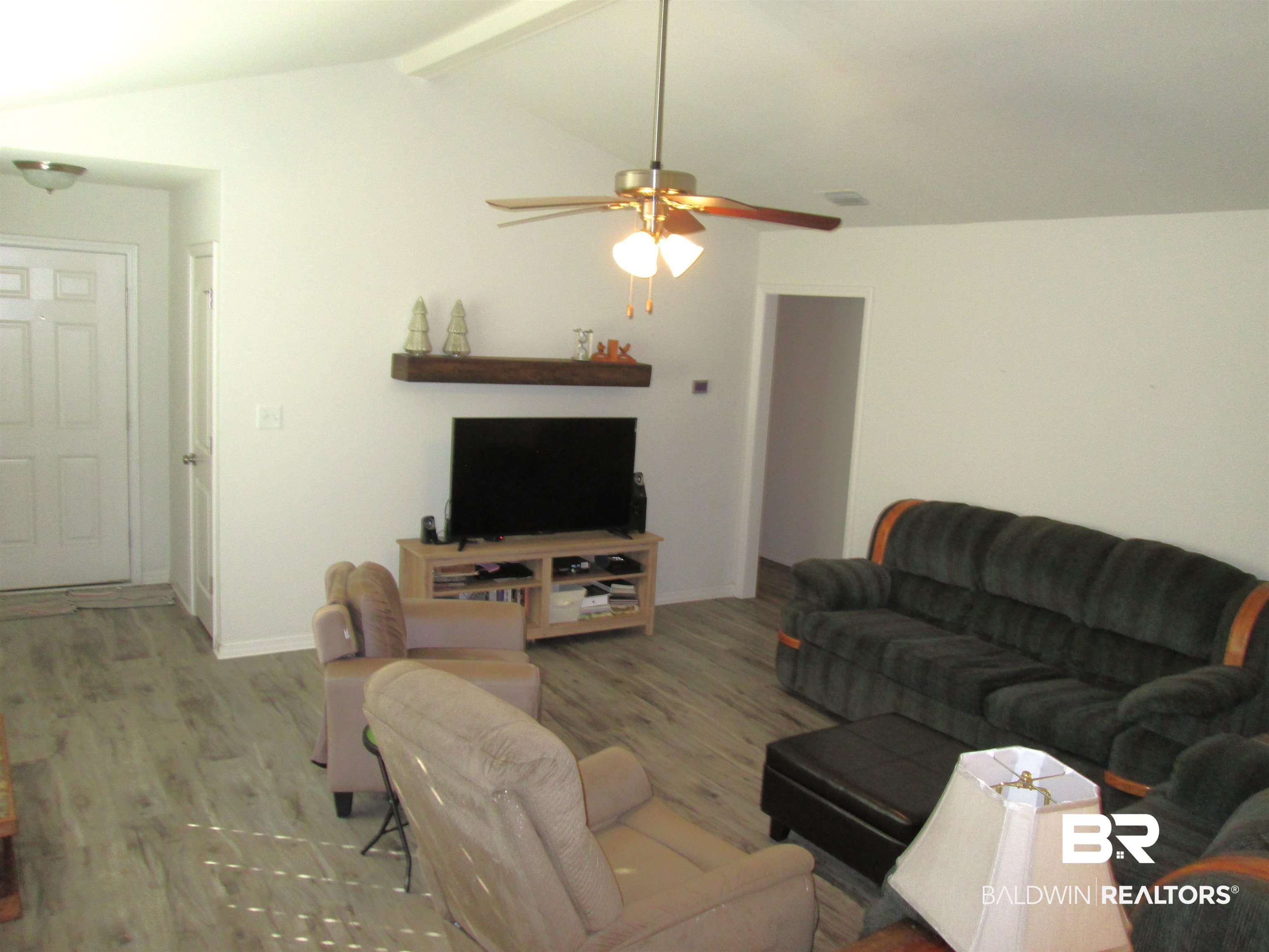 530 Brethren Church Road Fruitdale, AL 36539 - Photo 5 of 24 Living room with ceiling fan, lofted ceiling with beams, and light wood-type flooring