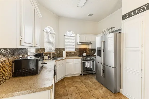 a kitchen with stainless steel appliances granite countertop a refrigerator sink and stove