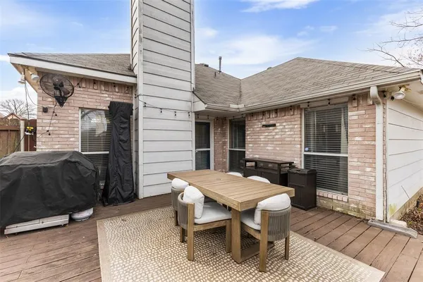 a view of a patio with table and chairs with wooden floor and fence
