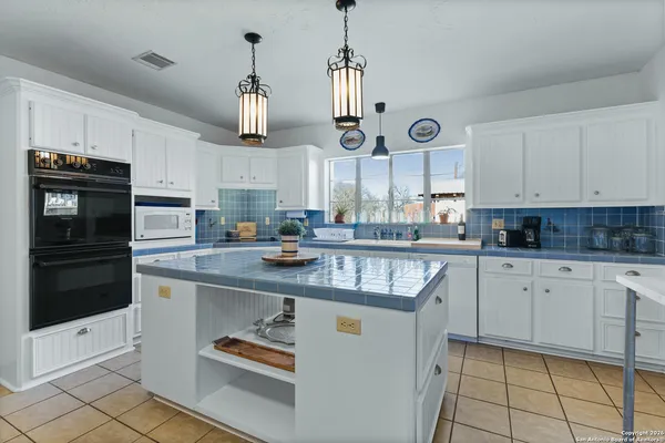 a kitchen with stainless steel appliances granite countertop a stove and cabinets