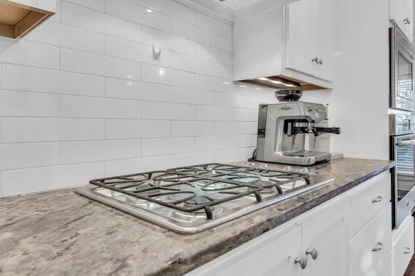 a stove top oven sitting inside of a kitchen