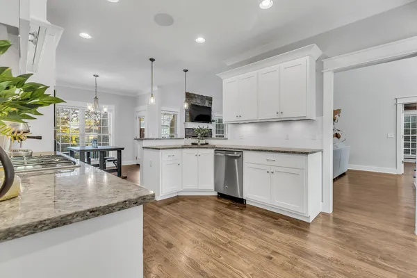 a kitchen with stainless steel appliances granite countertop a sink a stove and a wooden floors