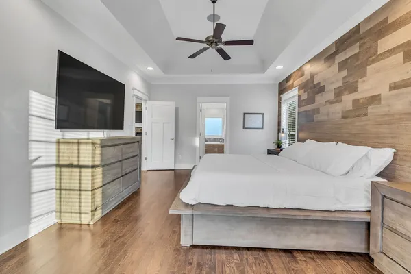a spacious bedroom with a bed and a flat screen tv