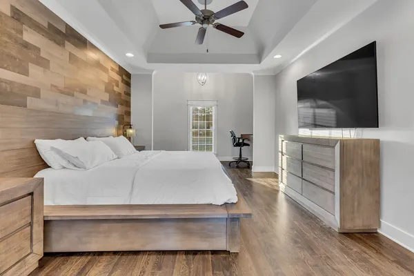 a spacious bedroom with a bed and a flat screen tv
