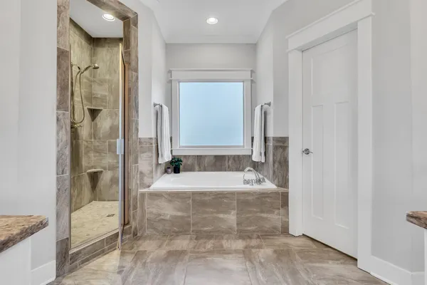 a bathroom with a tub shower and sink