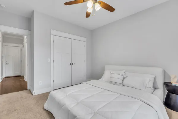 a bedroom with a large bed and a chandelier