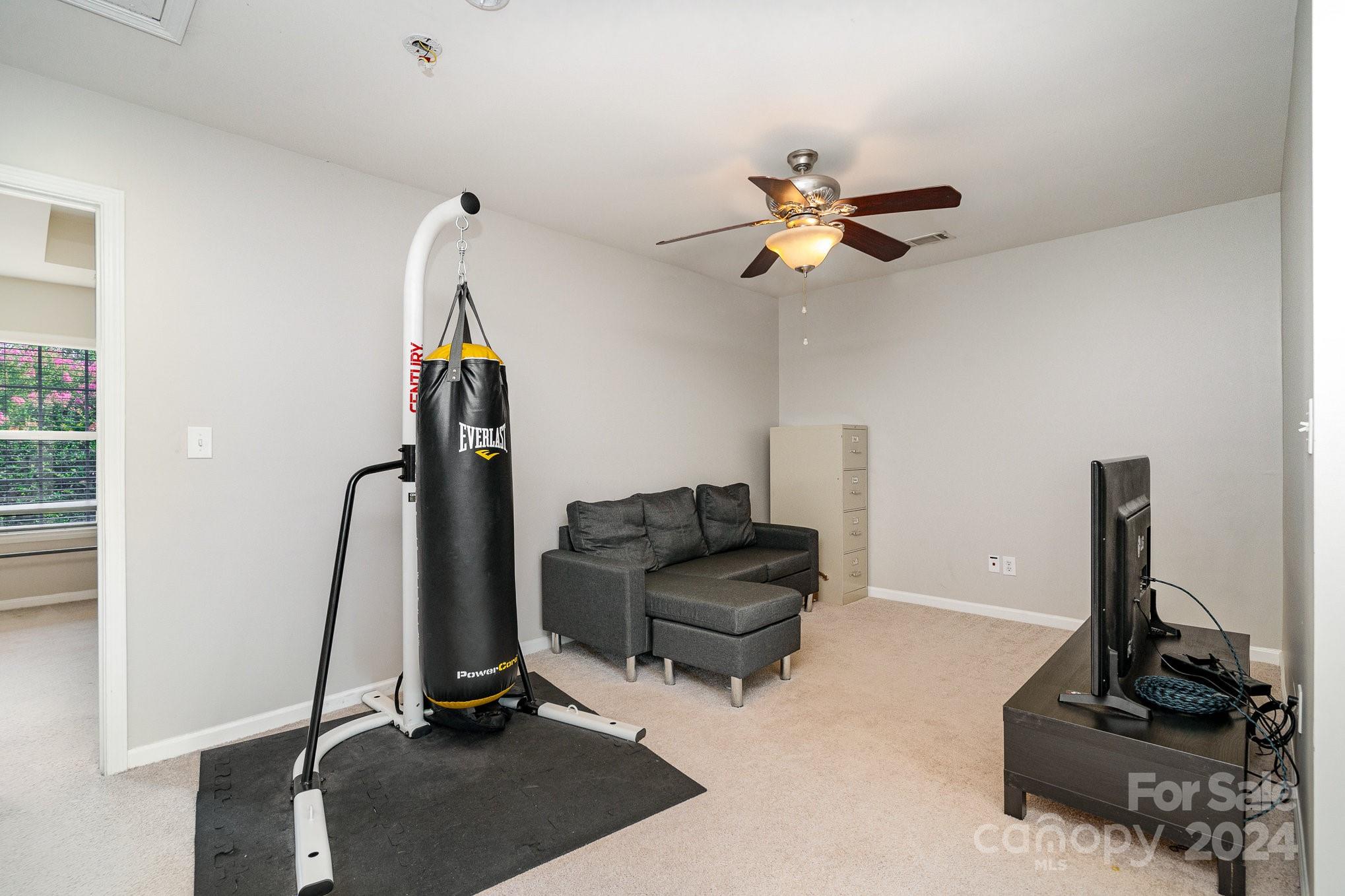 3367 Streamside Drive Davidson, NC 28036 - Photo 23 of 35 a living room with furniture gym equipment and a view of kitchen