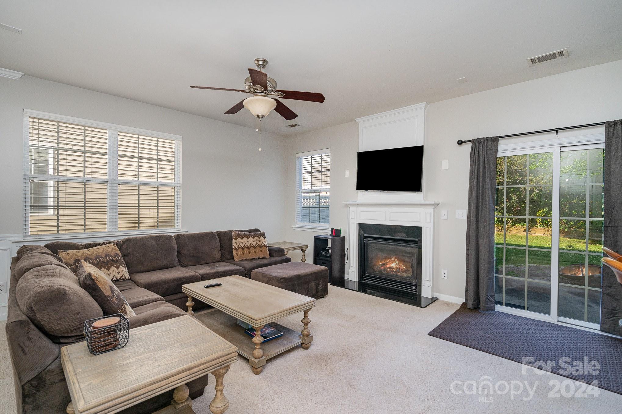 3367 Streamside Drive Davidson, NC 28036 - Photo 6 of 35 a living room with furniture a fireplace and a flat screen tv