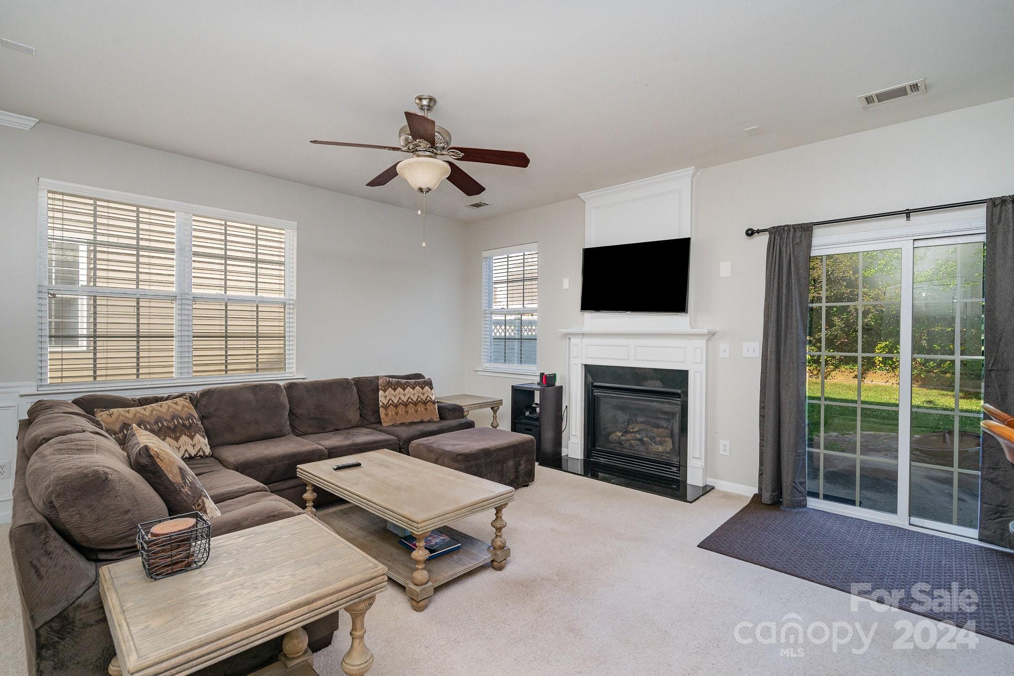 3367 Streamside Drive Davidson, NC 28036 - Photo 7 of 35 a living room with furniture a fireplace and a flat screen tv