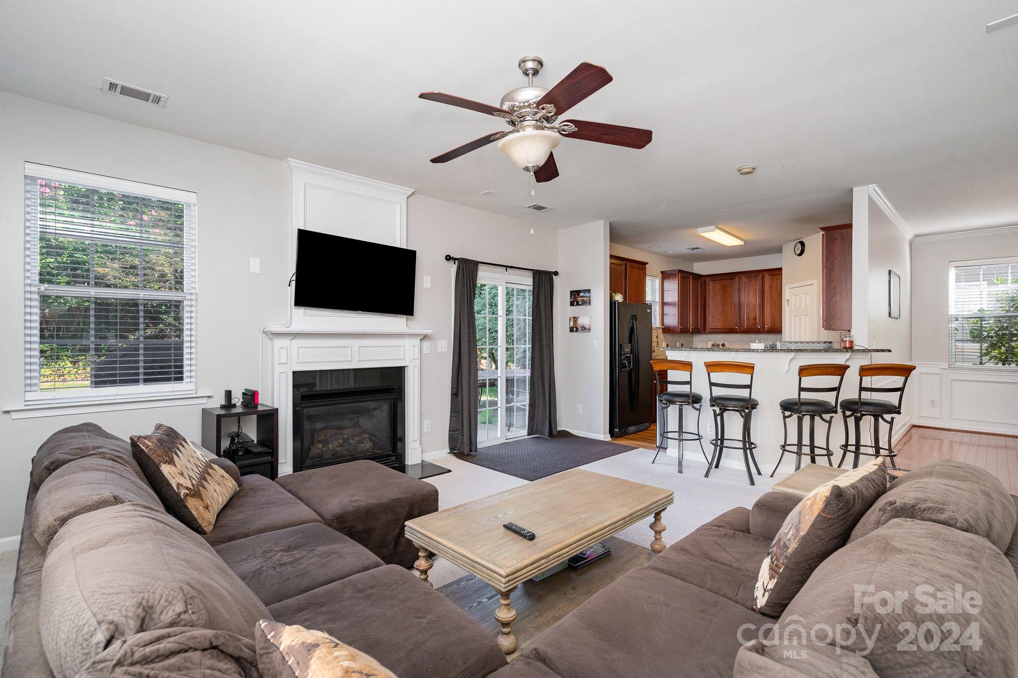 3367 Streamside Drive Davidson, NC 28036 - Photo 8 of 35 a living room with furniture a fireplace and a flat screen tv