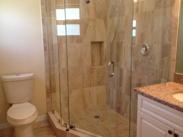 2855 Floral Road Lake Worth, FL 33462 - Photo 13 of 19 a bathroom with a granite countertop toilet a sink and shower