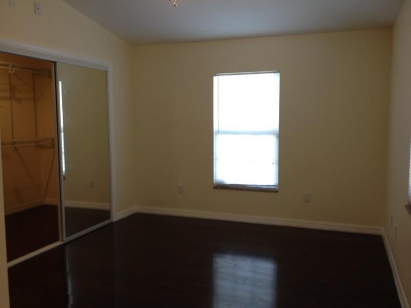 2855 Floral Road Lake Worth, FL 33462 - Photo 17 of 19 a view of an empty room with wooden floor and a window