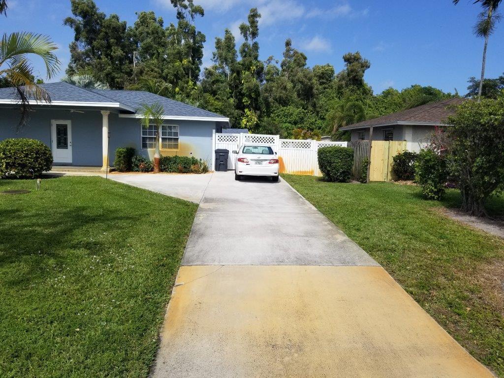 2855 Floral Road Lake Worth, FL 33462 - Photo 3 of 19 a front view of a house with a garden and trees