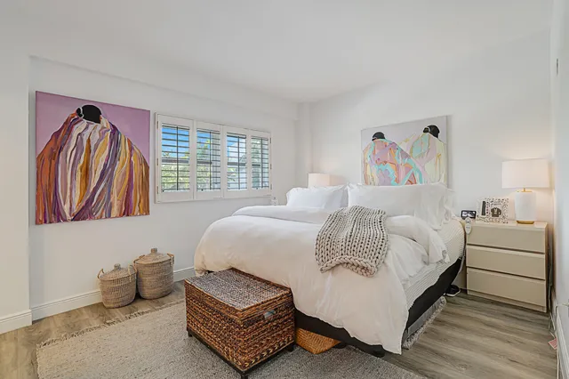 a bedroom with a bed and a painting on the wall